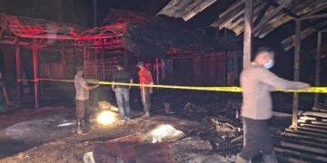 Petugas polisi memasang policeline pasca kebakaran, Minggu (6/8/2026). (ist)