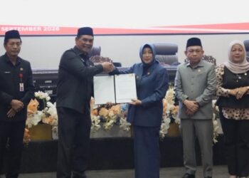 Bupati Barito Utara, H. Shalhuddin, dan Ketua DPRD Hj. Merry Rukaini, memperlihatkan berita persetujuan bersama Raperda Perubahan APBD, Kamis (17/9/2026).