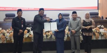 Bupati Barito Utara, H. Shalhuddin, dan Ketua DPRD Hj. Merry Rukaini, memperlihatkan berita persetujuan bersama Raperda Perubahan APBD, Kamis (17/9/2026).