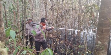 Kapolsek Dusun Timur, IPDA Sulkhan Sururi, memimpin pemadaman karhtla di Desa Telang, Kecamatan Paju Epat, Jumat (18/9/2026).