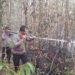 Kapolsek Dusun Timur, IPDA Sulkhan Sururi, memimpin pemadaman karhtla di Desa Telang, Kecamatan Paju Epat, Jumat (18/9/2026).