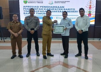 Bupati Barito Timur, M. Yamin menyerahkan penghargaan yang diterima Kajari Barito Timur Abdul Halim, Senin (19/10/2026).