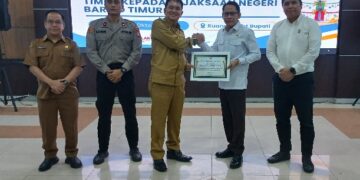Bupati Barito Timur, M. Yamin menyerahkan penghargaan yang diterima Kajari Barito Timur Abdul Halim, Senin (19/10/2026).