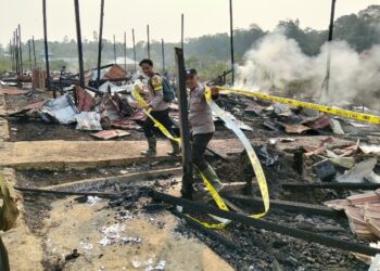 Polisi memasang police line di TKP kebakaran. (ist)