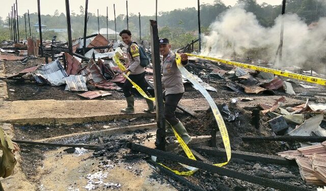 Polisi memasang police line di TKP kebakaran. (ist)