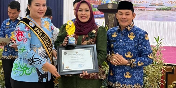Waket I DPRD Murung Raya Dina Maulidah, menerima penghargaan dari Wakil Bupati Murung Raya Rahmanto Muhidin, didampingi Bunda Literasi Kabupaten Murung Raya Warnita Heriyus, Kamis (8/10/2026).