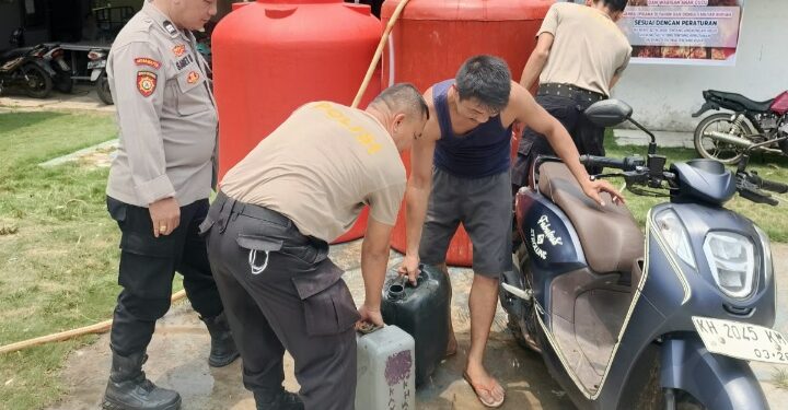 Penyaluran air bersih yang dilakukan personel Polsek Dusun Timur, Selasa (13/10/2026). (ist)